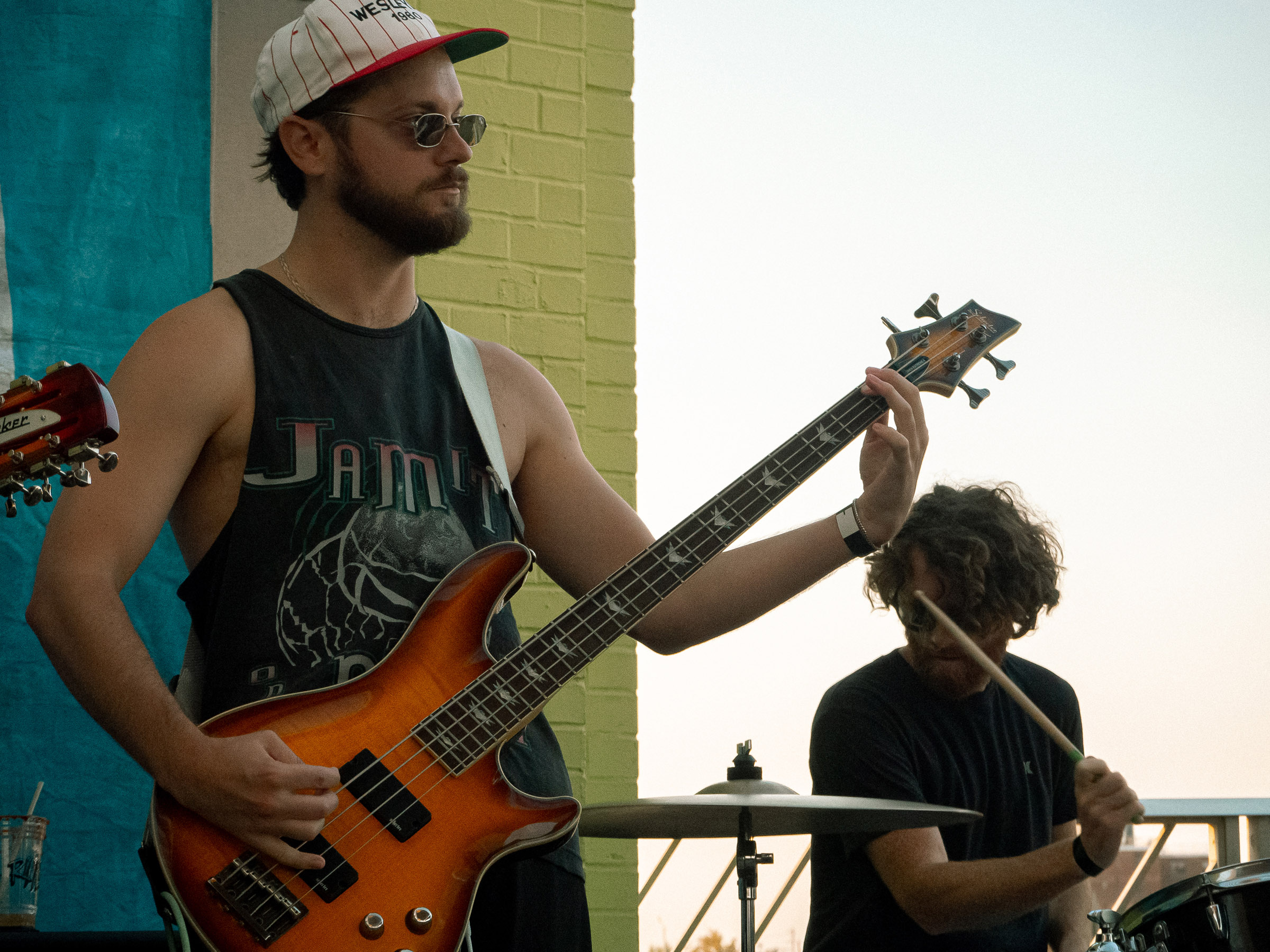 Bassist, Ethan, and drummer, Brendan, face forward and towards one another.