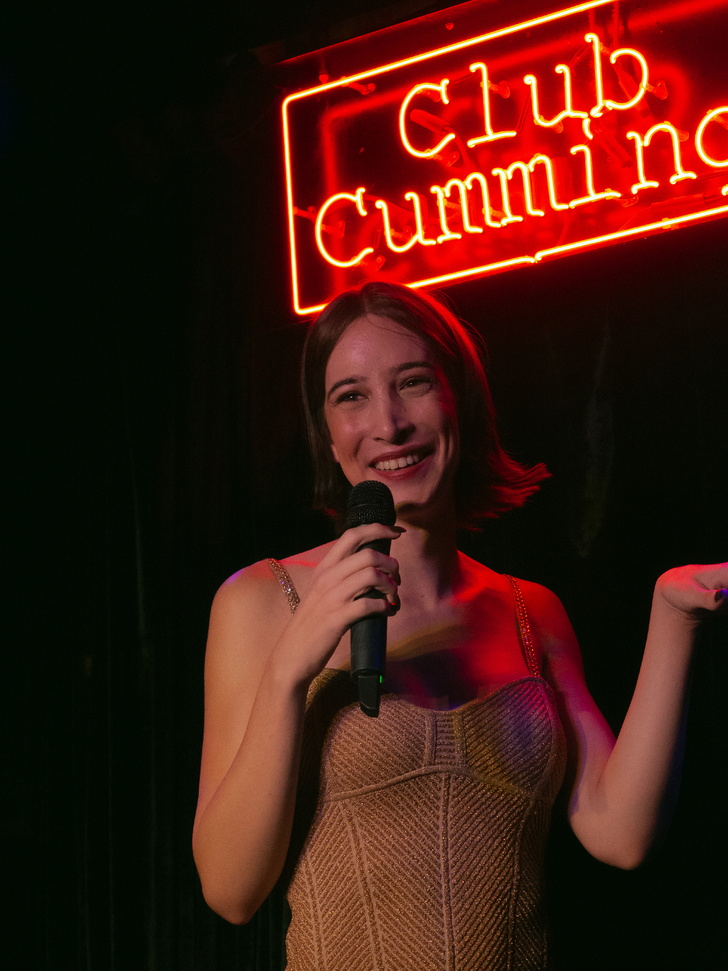Adrienne Hunter smiles under Club Cumming neon sign.