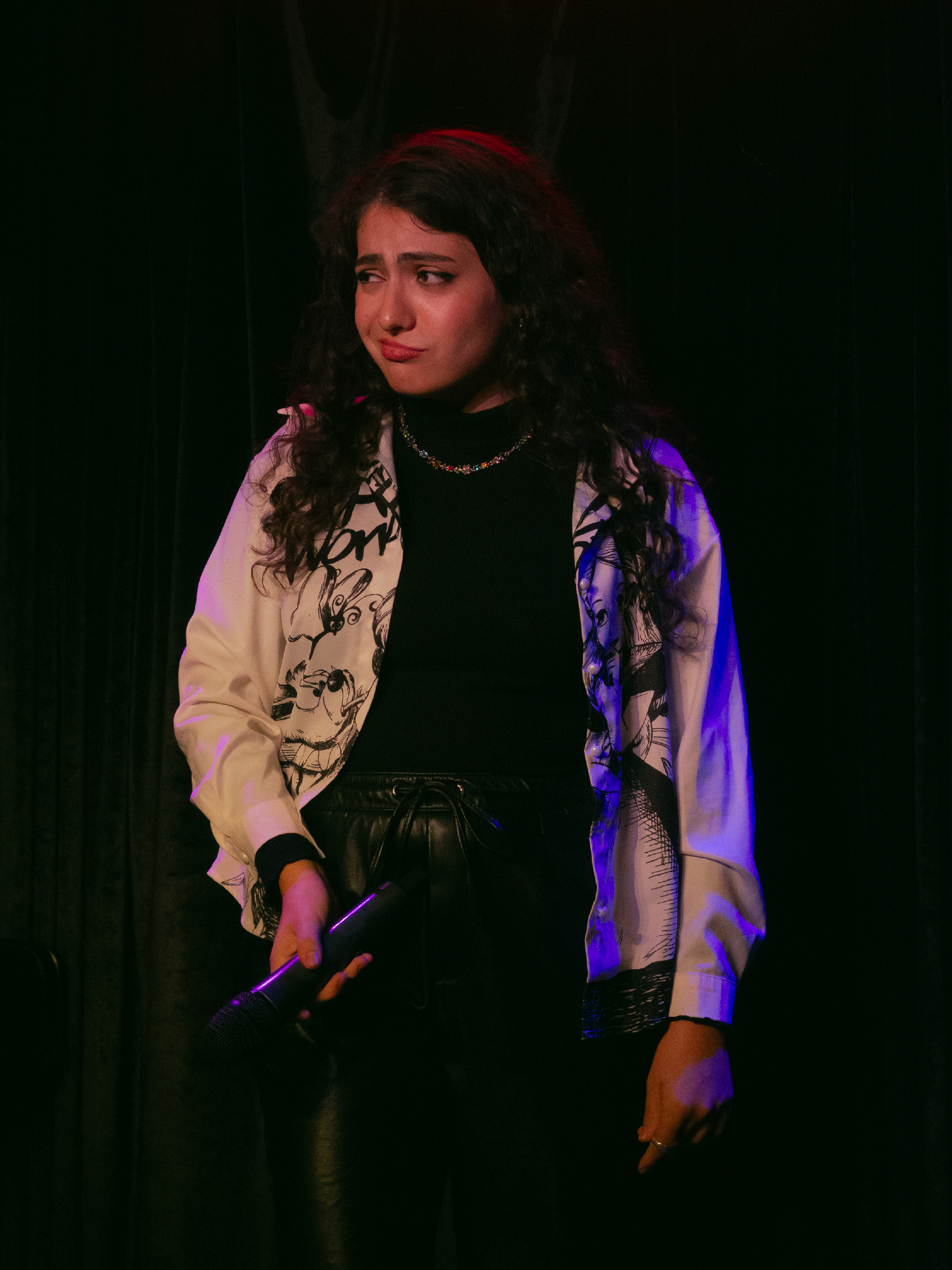 Anapaula Guajardo gestures with mic towards audience as if the mic is her penis.